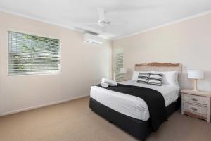 a bedroom with a large bed and a window at Rivershores in Noosaville