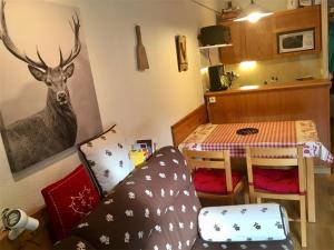 a living room with a table and a deer painting on the wall at Appartement Les Angles, 2 pièces, 4 personnes - FR-1-295-149 in Les Angles