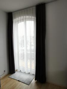 a room with a large window with black curtains at Sehr Schönes 2 Zimmer Maisonnette Wohnung in Ansbach