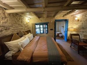 マックトシュワーにあるSHIVAYA since 1953の石造りの部屋に大型ベッドが備わるベッドルーム1室
