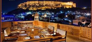 een restaurant met een tafel en uitzicht op de stad bij Haveli in Jodhpur