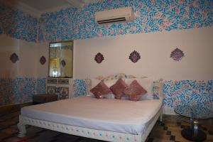 een slaapkamer met een bed met blauw en wit behang bij Haveli in Jodhpur