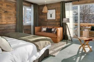 a bedroom with a bed and a chair at MOUNTAIN LODGE OBERJOCH, BAD HINDELANG - moderne Premium Wellness Apartments im Ski- und Wandergebiet Allgäu auf 1200m, Family owned, 2 Apartments mit Privat Sauna in Bad Hindelang