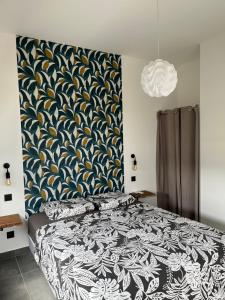 a bedroom with a bed with a blue and yellow patterned wall at CAPLINE in Saint-Benoît