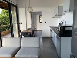 a kitchen and living room with a couch and a table at CAPLINE in Saint-Benoît
