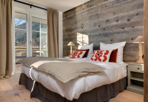 a bedroom with a large bed with a wooden wall at MOUNTAIN LODGE - Neueröffnung 2023 moderner Premium Wellness Appartments, Ski-in Ski-out, Family owned in Oberjoch