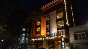 un edificio con un cartel que lee hotel patriarcal por la noche en The President Hotel, kumarapark, en Bangalore