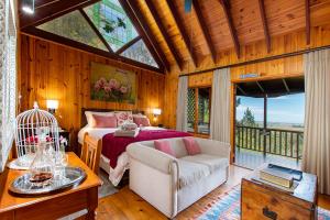 a bedroom with a bed and a couch and a table at ArendsRus Country Lodge in Molen Drift