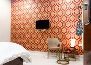 1 dormitorio con 1 cama, TV y silla en Radha Krishna Bhawan, Homestay en Vrindāvan
