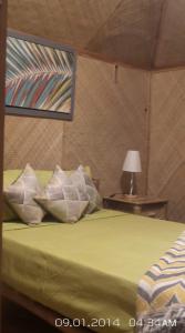San Francisco的住宿－Paraiso Cave & Restaurant & Resort，一间卧室配有一张绿色的床和一张带台灯的桌子