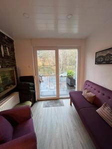 a living room with a purple couch and a large window at Haus Osterlämmchen in Ediger-Eller