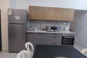 a kitchen with a refrigerator and a table with chairs at צימר מתאים לדתיים בלבד in Yavneʼel