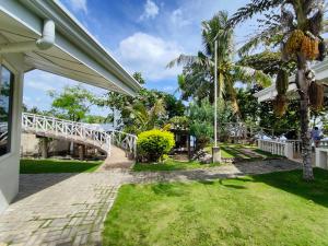 a white house with a walkway and palm trees at Meili Beach Resort in Alcoy