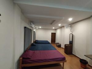 een kamer met drie bedden in een kamer met bij Azhar lodge koyilandy in Kozhikode
