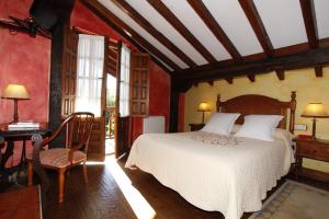 a bedroom with a bed and a table and a desk at La Casa del Organista in Santillana del Mar