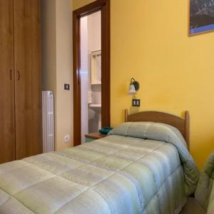 een slaapkamer met een bed in een gele kamer bij Hotel Giampy in Assergi