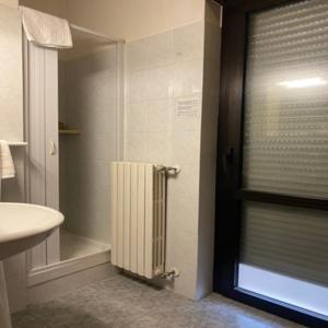 een badkamer met een douche en een wastafel bij Hotel Giampy in Assergi