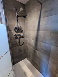 a bathroom with a shower with a shower head at La Rogeraie Cap gris nez in Audinghen +30 photos