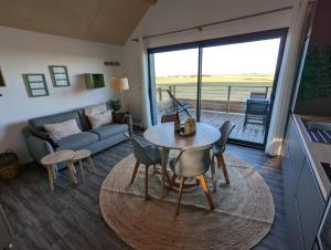 a living room with a table and chairs and a couch at La Rogeraie Cap gris nez in Audinghen