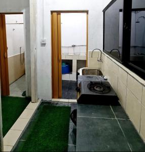 a room with a bathroom with a sink and grass at Rainbow Lodge Tambatuon in Kota Belud