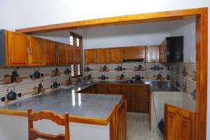 a kitchen with wooden cabinets and a counter top at Amis Hotel & Restaurant in Jaffna
