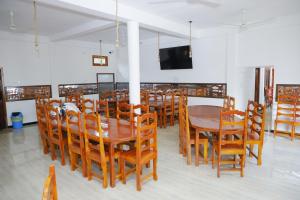 - une salle à manger avec une table, des chaises et une télévision dans l'établissement Amis Hotel & Restaurant, à Jaffna