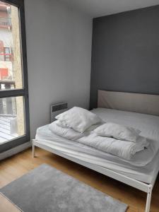 ein weißes Bett in einem Zimmer mit Fenster in der Unterkunft Jolies Appartement 6 couchages a praloup 1600 avec balcons in Uvernet
