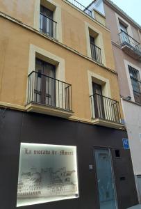 Un edificio con un cartel al costado. en La Morada de Moret, en Cáceres