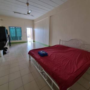 a bedroom with a bed with a red comforter at Sorworakit Hotel in Bangsaen