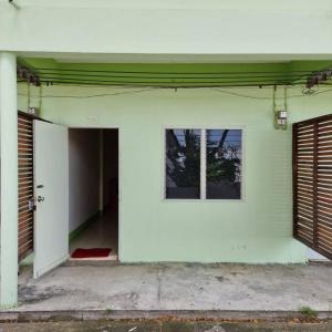 una puerta abierta de un edificio blanco con ventana en Sorworakit Hotel, en Bang Saen