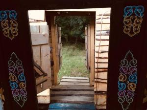 uma porta aberta para uma casa com uma escada em Mongolian yurt sleeping 2+2 with outdoor space em Llanbrynmair