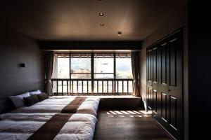 Itoshima 810 Villa & Resort في Keya: سرير كبير في غرفة مع نافذة كبيرة