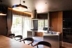a kitchen with a table and chairs and a sink at Itoshima 810 Villa & Resort in Keya