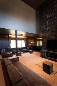 a living room with a couch and a fireplace at Itoshima 810 Villa & Resort in Keya