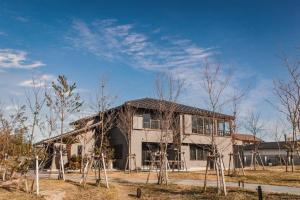 una casa con árboles delante de ella en Itoshima 810 Villa & Resort en Keya