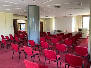 um quarto grande com cadeiras vermelhas e um pilar em Hotel Grassetti em Corridonia