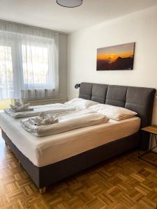 a bedroom with a large bed with a sunset painting on the wall at Apartments Bergblick in Sonnenalpe Nassfeld