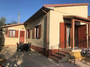 een patio met stoelen en een tafel en een huis bij Appartamento Trilocale “Il Regio” in Montescudaio