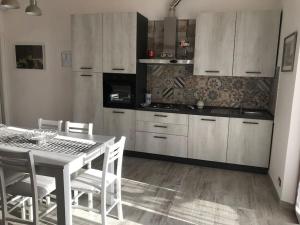 een keuken met een tafel en stoelen en een tafel bij Appartamento Trilocale “Il Regio” in Montescudaio