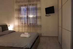 een slaapkamer met een bed met een witte handdoek erop bij Appartamento Trilocale “Il Regio” in Montescudaio