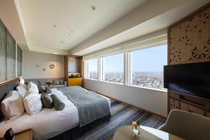 a hotel room with a large bed and a large window at Hotel Nikko Kanazawa in Kanazawa