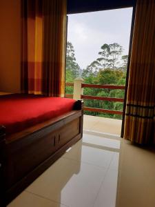 a bedroom with a bed and a window with a view at Delhousie Hotel in Adams Peak