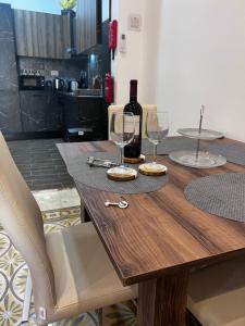 - une table en bois avec 2 verres et une bouteille de vin dans l'établissement Dar Barbara - Duplex 1 Double bedroom Maisonette, à Cospicua