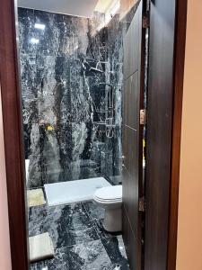 a bathroom with a toilet and a black marble wall at Dar Barbara - Duplex 1 Double bedroom Maisonette in Cospicua