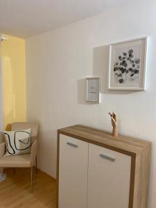 a room with a white cabinet and a chair at Ferienwohnung Vater Rhein Mittelrheintal in Sankt Goar