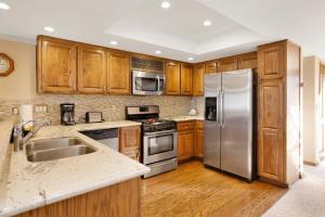 une cuisine avec des placards en bois et des appareils en acier inoxydable dans l'établissement 2250-Forest Shores Lake View Condo Combo home, à Big Bear Lake