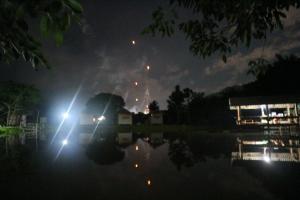 a night time view of a pond with lights at Samoeng fishing park home stay in Samoeng