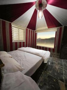 a room with two beds in a tent with a window at Bright stars rum camp in Wadi Rum
