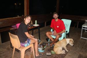 two people sitting in chairs with a dog at Samoeng fishing park home stay in Samoeng