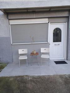 duas cadeiras e uma mesa em frente a uma garagem em Guest Room em Serres